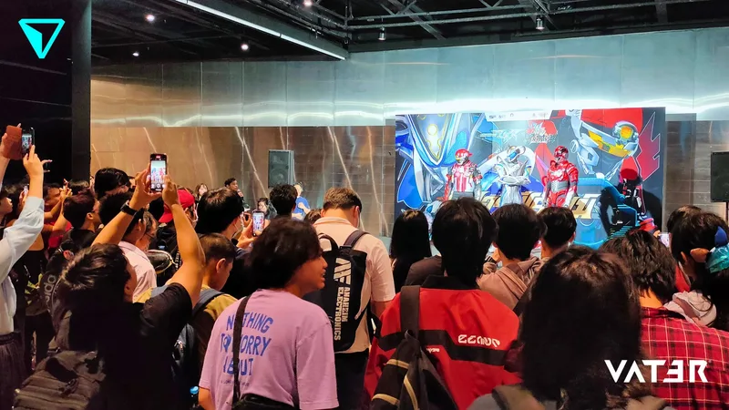 ฝูงชนกำลังชมและถ่ายภาพการแสดงของซูเปอร์ฮีโร่บนเวทีในงานอีเวนต์ในร่ม