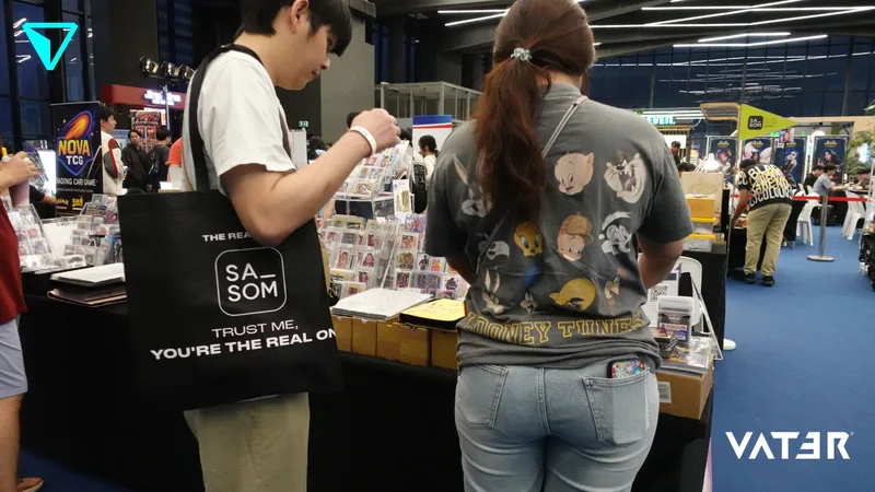 ชายสะพายกระเป๋าผ้าและหญิงใส่เสื้อ Looney Tunes ยืนเลือกดูสินค้าตามบูธในงานนิทรรศการในร่ม