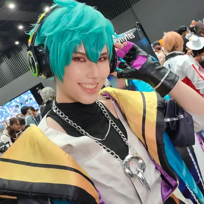 คอสเพลเยอร์ในชุด HEARTSTEEL Ezreal ยิ้มและโพสท่าในฮอลล์จัดงานคอนเวนชันที่เนืองแน่นไปด้วยผู้คน