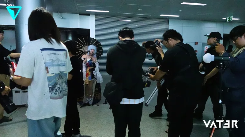 ช่างภาพและผู้เข้าร่วมงานรวมตัวกันถ่ายภาพคอสเพลเยอร์ที่กำลังถือร่มโพสท่าในศูนย์ประชุม