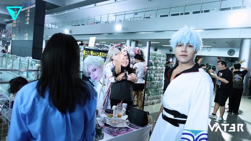 คอสเพลเยอร์แต่งกายเป็น Gintoki Sakata จาก Gintama ยืนที่บูธในงานอนิเมะท่ามกลางผู้เข้าร่วมงาน