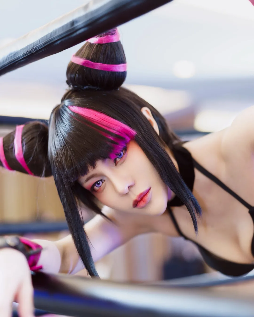 คอสเพลเยอร์ในชุด Juri Han จาก Street Fighter โพสท่าอยู่ระหว่างเชือกเวทีมวย