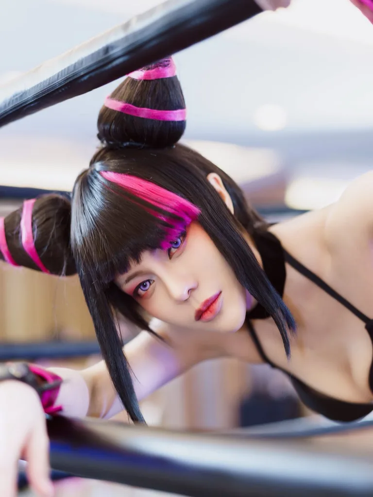 คอสเพลเยอร์ในชุด Juri Han จาก Street Fighter โพสท่าอยู่ระหว่างเชือกเวทีมวย