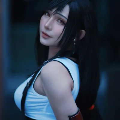คอสเพลเยอร์แต่งกายเป็น Tifa Lockhart จาก Final Fantasy VII หันมองข้ามไหล่ในชุดเสื้อกล้ามสีขาวและสายเอี๊ยม