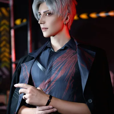 คอสเพลเยอร์แต่งกายเป็น Sylus จาก Love and Deepspace ไว้ผมสั้นสีเงิน โพสท่าในเสื้อเชิ้ตสีดำและเสื้อโค้ตพาดไหล่