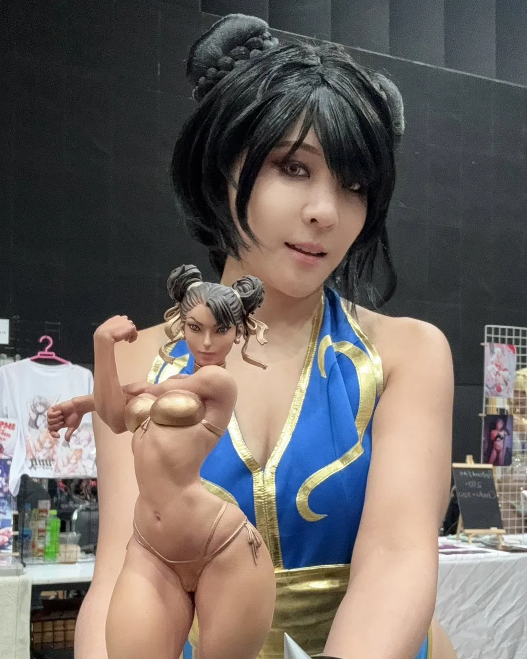 คอสเพลเยอร์ในชุด Chun-Li ถือฟิกเกอร์ของตัวละครในชุดบิกินีสีทองที่งานจัดแสดง