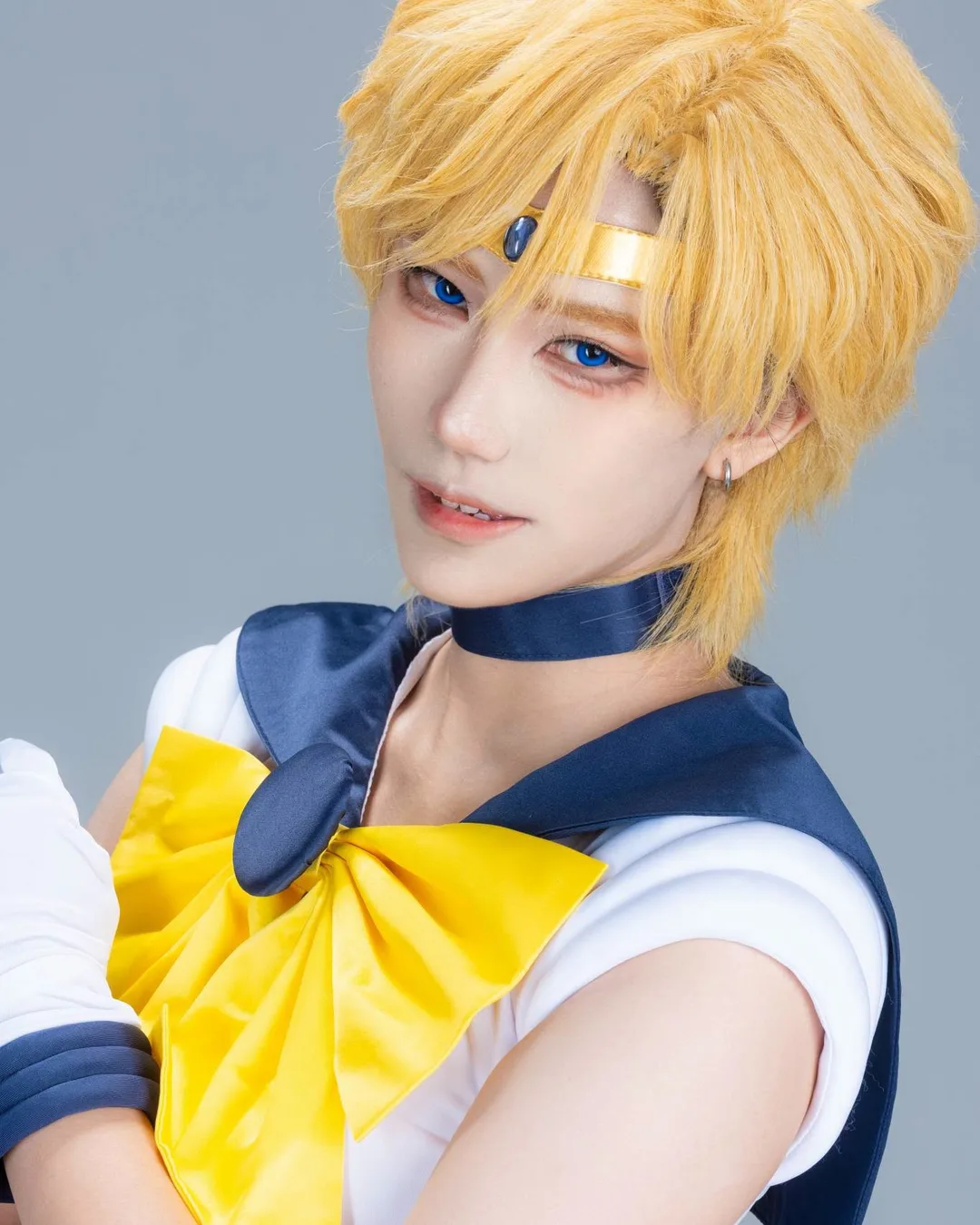 คอสเพลเยอร์แต่งกายเป็น Sailor Uranus พร้อมผมสั้นสีบลอนด์ มงกุฎสีทอง และชุดกะลาสีติดโบสีเหลืองขนาดใหญ่