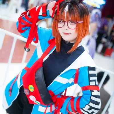 คอสเพลเยอร์แต่งกายเป็น Dantsu Flame จาก Uma Musume สวมแว่นตาสีแดงและหูสัตว์ โพสท่าในงานอีเวนต์ในร่ม