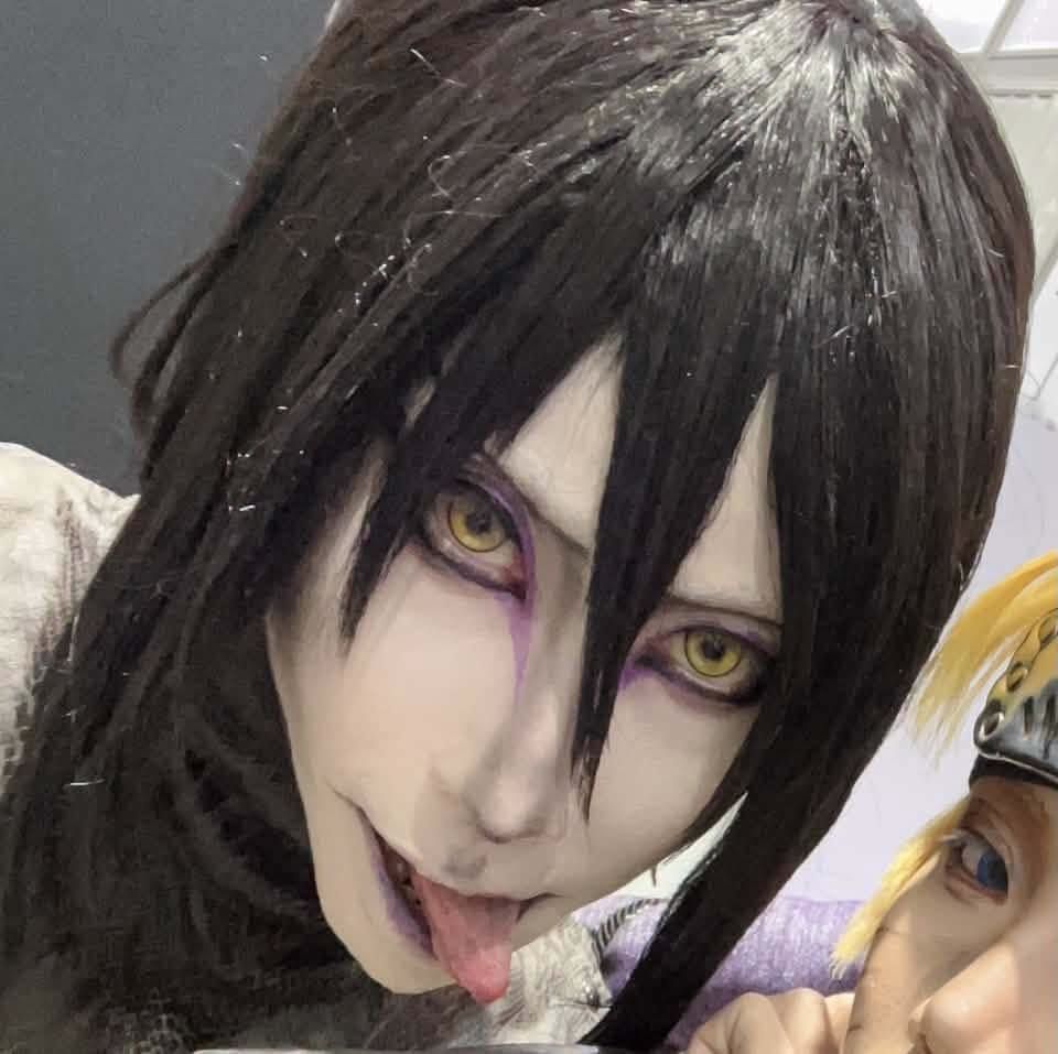 คอสเพลเยอร์ที่แต่งตัวเป็น Orochimaru จาก Naruto แลบลิ้นขณะโพสท่าคู่กับคอสเพลเยอร์ Naruto