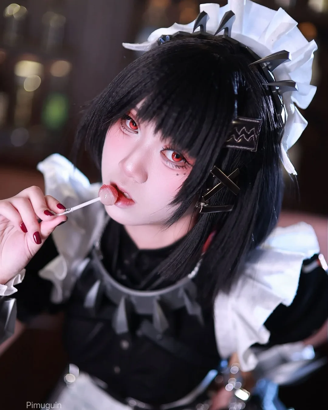 คอสเพลเยอร์ในชุด Ellen Joe จาก Zenless Zone Zero ถืออมยิ้มแตะที่ริมฝีปากในชุดเมดสไตล์โกธิก