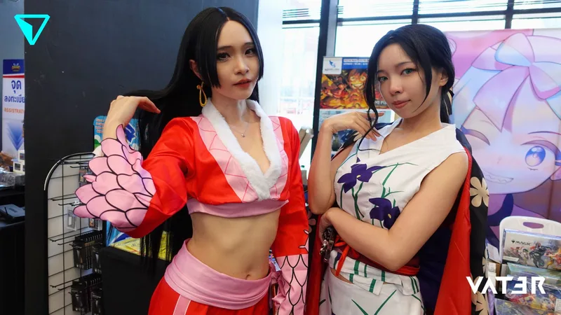 หญิงสาวสองคนคอสเพลย์เป็นตัวละครจาก One Piece ยืนโพสท่าร่วมกันที่บูธในงานมหกรรมอนิเมะ