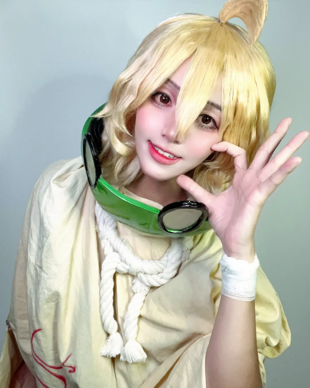 คอสเพลเยอร์แต่งกายเป็น Suika จาก Dr. STONE ยิ้มอย่างสดใสโดยมีหน้ากากแตงโมคล้องอยู่ที่คอ