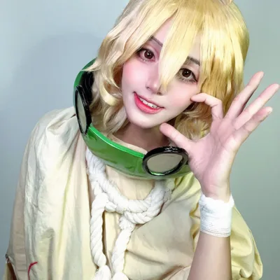 คอสเพลเยอร์แต่งกายเป็น Suika จาก Dr. STONE ยิ้มอย่างสดใสโดยมีหน้ากากแตงโมคล้องอยู่ที่คอ