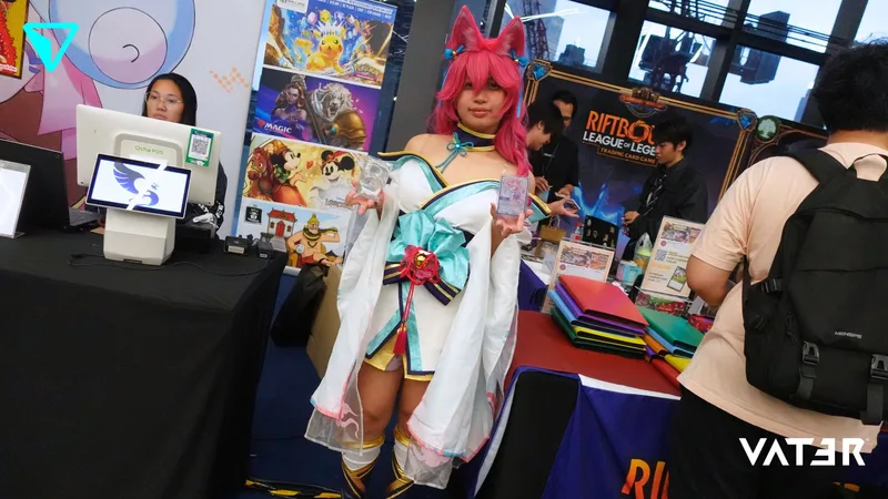 คอสเพลเยอร์ในชุด Spirit Blossom Ahri ผมสีชมพูพร้อมหูจิ้งจอกโพสท่าหน้าบูธในงานเกม