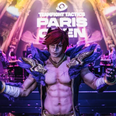 A cosplayer dressed as Sett from League of Legends poses shirtless on a lighted stage at the Teamfight Tactics Paris Open event.