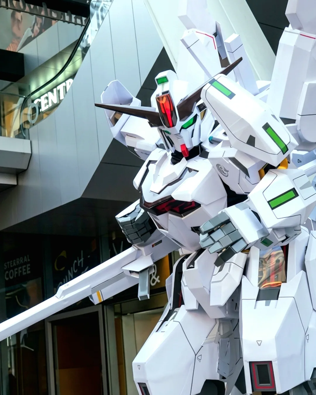 คอสเพลเยอร์ในชุดหุ่นยนต์ Gundam Calibarn สีขาวสุดอลังการ ยืนอยู่ท่ามกลางผู้ร่วมงานในฮอลล์จัดแสดง